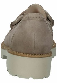 Scarpa in suede marrone chiaro con una forma arrotondata, dotata di una suola testurizzata e una base in gomma beige. Include dettagli decorativi con bottoni.