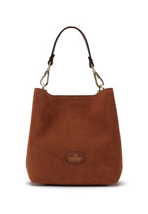 Sac à main en daim marron avec une lanière marron foncé unique attachée par des fermoirs dorés et un petit patch de logo à l’avant.