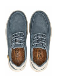 Niebieskie zamszowe buty z przeszyciami, sznurowane, z wyściełaną korkową wkładką, białą gumową podeszwą i żółtym akcentem z boku.