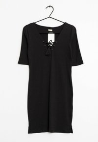 Černé žebrované šaty s výstřihem do V, detaily na šněrování vpředu a krátkými rukávy. Obsahují také akcent s třásněmi a boční rozparky na lemu.