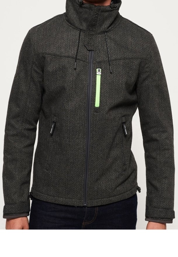 Veste texturée gris foncé avec col montant et fermeture éclair. Présente un accent de fermeture éclair vert et des poches latérales. Conçue pour la chaleur.