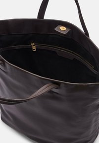 Dunkelbraune Ledertasche mit glatter Textur, ausgestattet mit einer Reißverschlusstasche, goldfarbenen Beschlägen und stabilen Trägern. Das Innere ist mit schwarzem Stoff ausgekleidet.