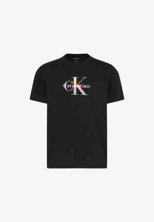 Must värvilise "CK Calvin Klein" logoga lühikeste varrukatega ümara kaelusega t-särk, mille logo asub rindkere keskosas.