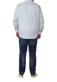 Hellblau gemustertes Hemd mit langen Ärmeln, kombiniert mit dunkelblauen Jeans. Das Hemd hat kleine Rautenmuster und einen Button-Down-Kragen.