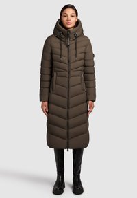 Garšs, ar kapuci puffer mētelis olīvzaļā krāsā, ar dimanta šuvju rakstu, priekšējo rāvējslēdzēju un sānu kabatām. Gluda tekstūra un silta izolācija.