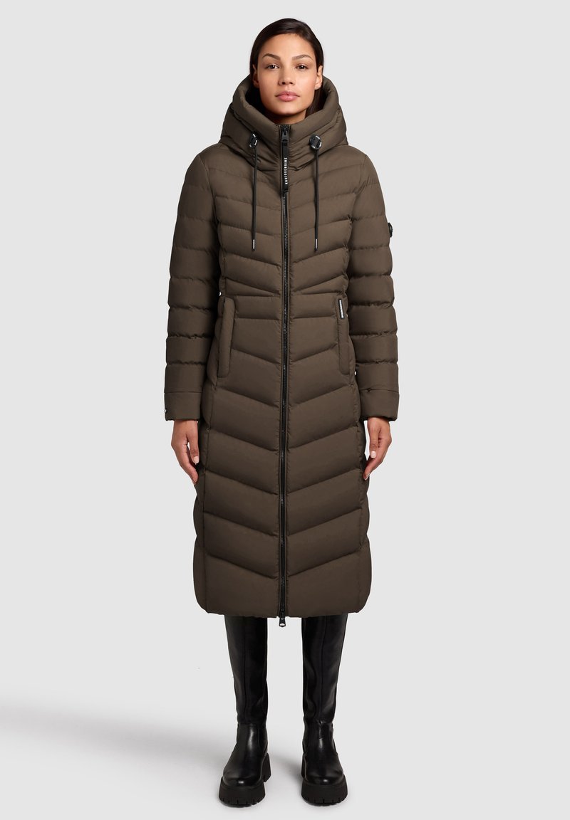 Garšs, ar kapuci puffer mētelis olīvzaļā krāsā, ar dimanta šuvju rakstu, priekšējo rāvējslēdzēju un sānu kabatām. Gluda tekstūra un silta izolācija.