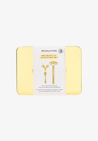 Lattina di metallo dorato con un'etichetta per il "Pro Miracle Sculpting Set." L'etichetta mostra tre strumenti per scolpire il viso.