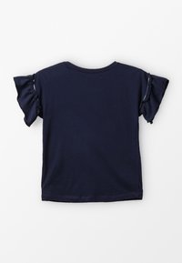 Námořnická modrá tričko s krátkým rukávem vyrobené z bavlny, se skládacími rukávy a kulatým výstřihem. Hladká textura s volnějším střihem.