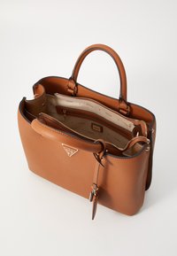 Brown leather handbag with zip closure and dual top handles; interior features multiple pockets and a subtle logo print lining.