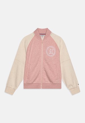 Jasnoróżowa i kremowa kurtka na zamek z prążkowanym kołnierzem i mankietami, bocznymi kieszeniami oraz białym emblematem "H" na lewej piersi.
