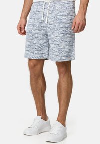Bañadores para hombre con estampado en azul claro y blanco, que cuentan con una cinturilla elástica, cordón y bolsillos laterales. Tejido texturizado con diseño geométrico.