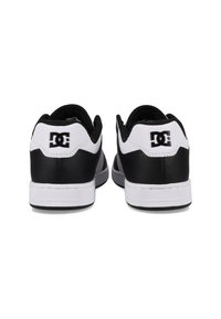 Black and white sneaker with a smooth leather upper, padded collar, and solid rubber soles. Features the DC logo on the heel.