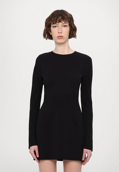 Robe noire à manches longues avec un col rond, corsage ajusté et jupe évasée. Elle présente un tissu lisse et un design minimaliste.