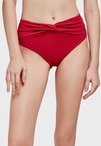 Dámské červené bikiny s vysokým pasem a twist designem v přední části, vyrobené z texturované tkaniny. Hladké okraje a přiléhavý střih.