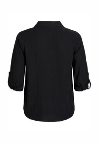 Camisa negra de manga larga con botones, con cuello y mangas remangadas. Hecha de una tela texturizada con un dobladillo recto.