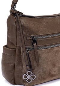 Borsa a mano in pelle marrone con superficie texture, tasche doppie con zip e un charm metallico decorativo attaccato alla zip.