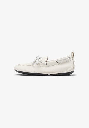 Mocassin en cuir blanc avec détail de lacet, semelle noire et languette au talon, vu de côté sur fond blanc.