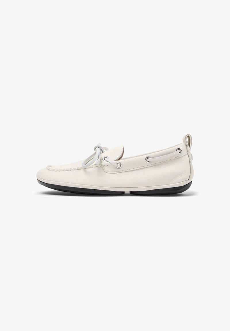 Mocassin en cuir blanc avec détail de lacet, semelle noire et languette au talon, vu de côté sur fond blanc.
