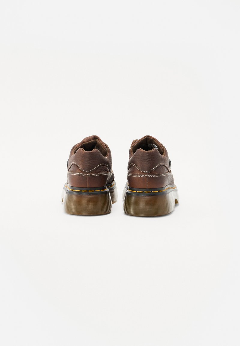 Braune Lederschuhe mit strukturiertem Finish, runder Spitze und einer massiven, gerippten Sohle. Sie verfügen über kontrastierende gelbe Nähte an den Seiten.