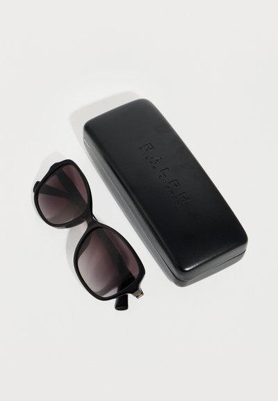 Μαύρα υπερμεγέθη γυαλιά ηλίου με σκουρόχρωμους φακούς δίπλα σε ορθογώνια μαύρη θήκη με τη σήμανση Ralph Lauren σε λευκή επιφάνεια.