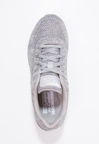 Ljusgrå sportskor med ovandel i vävt mesh, snörning och vadderad krage. Har en sula i minnesskum och logodetaljer.