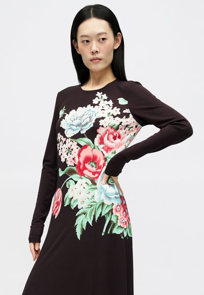 Sukienka z długim rękawem w ciemno-brązowym materiale, z dużym kwiatowym wzorem w odcieniach różu, niebieskiego i zielonego. Dopasowana sylwetka z okrągłym dekoltem.