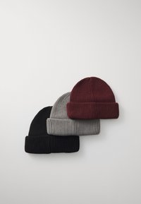 Three knit beanies stacked horizontally: black, gray, and burgundy. Each features a ribbed texture and a rolled cuff.