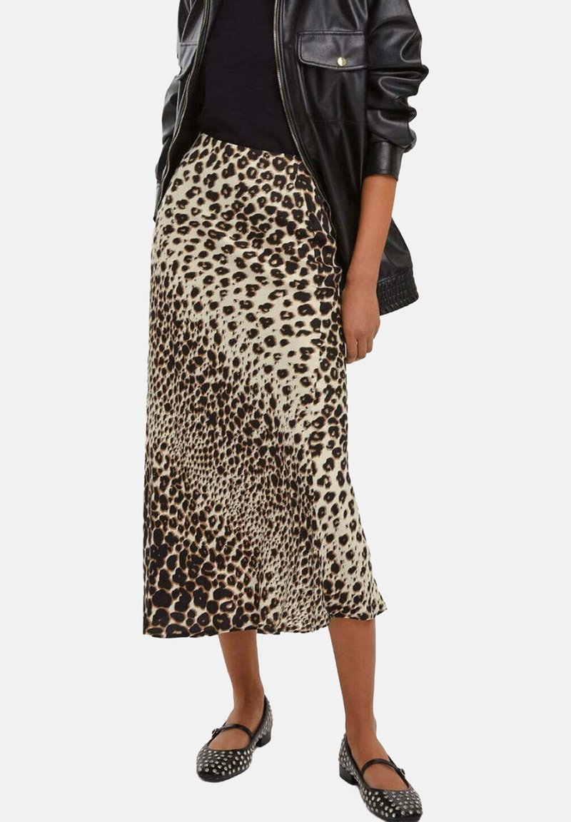 Gonna midi in stampa leopardata con una texture di tessuto liscia, caratterizzata da una forma ad A e uno spacco laterale, abbinata a una giacca di pelle nera e scarpe flat.