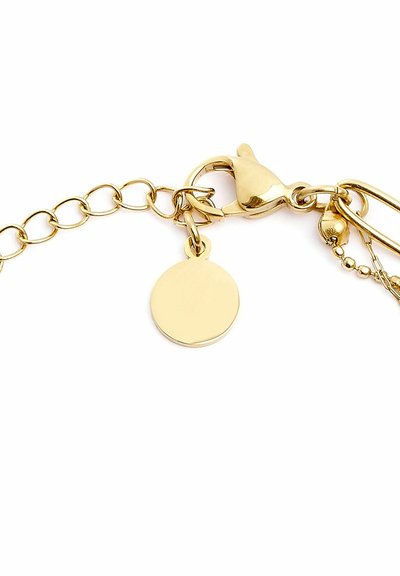 Bracciale in oro con design a catena, dotato di un pendente piatto rotondo e di una chiusura a moschettone. Texture liscia e finitura lucida.