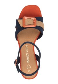 Sandalia de mujer con un empeine azul marino, tiras beige y una hebilla naranja, textura de ante y plantilla marrón con acolchado.