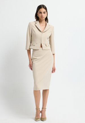 Blazer beige ajusté avec des manches trois-quarts et des poches avant, assorti d'une jupe crayon à mi-mollet, tissu lisse, design ajusté.