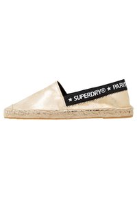 Espadrille metálico dorado con una banda elástica negra que presenta el texto "SUPERDRY® PARÍS". Suela de cuerda de yute. Textura suave; diseño de punta afilada.