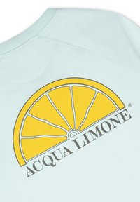 Ljusblå sweatshirt med en gul, grafisk citronskivedesign ovanför texten "ACQUA LIMONE," med en mjuk textur.