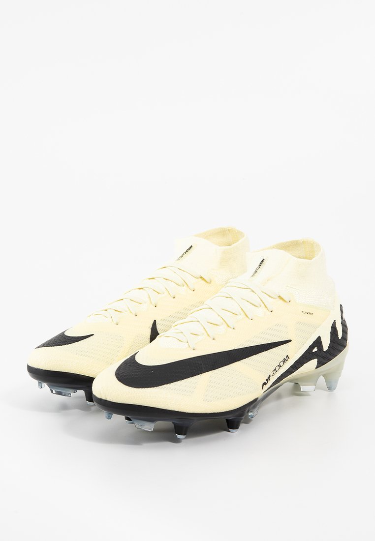 Crampons de football jaunes avec un swoosh noir, col en tricot, empeigne texturée et semelle transparente à plusieurs crampons pour une meilleure adhérence.