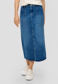 Donkerblauw denim midi-jurk met twee voorzakken, zichtbare stiksels, een knoopsluiting en een rechte silhoeët. Draagt het met witte sneakers.