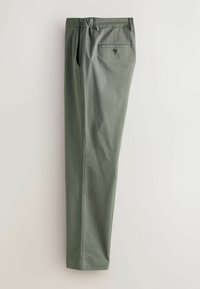 Zelené bavlněné kalhoty rovného střihu, s dvěma bočními kapsami a jednou zadní kapsou se zapínáním na knoflík. Hladký povrch, minimalistický design.