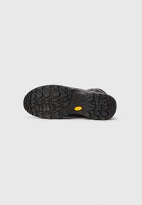 Zwarte hikingbootzool met diepe profiel, voorzien van een gele Vibram-logo en een gestructureerd rubber voor grip op verschillende oppervlakken.