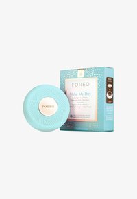 Foreo UFO-enhet i lyseblå silikon med teksturert overflate, kombinert med en mintfarget og gullmønstret eske merket "Make My Day."
