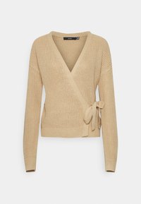 Beżowy sweter z dzianiny w formie narzutki z dekoltem w kształcie V, długimi rękawami, wiązaniem z boku oraz prążkowanymi mankietami i dołem. Teksturowany materiał dodaje głębi.
