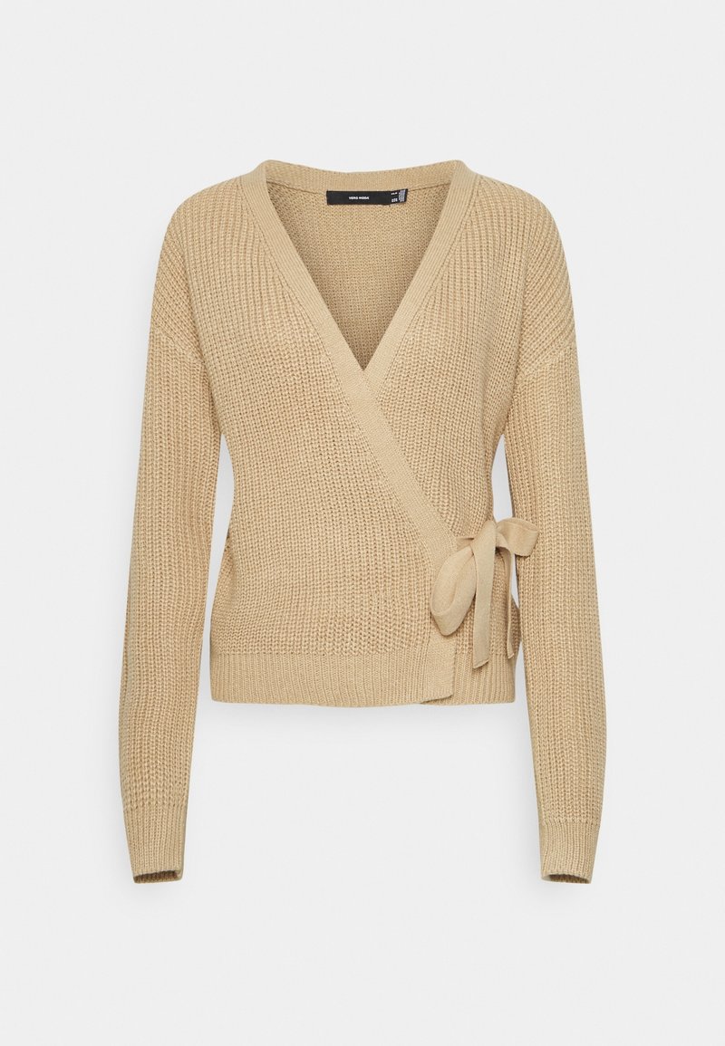 Beżowy sweter z dzianiny w formie narzutki z dekoltem w kształcie V, długimi rękawami, wiązaniem z boku oraz prążkowanymi mankietami i dołem. Teksturowany materiał dodaje głębi.