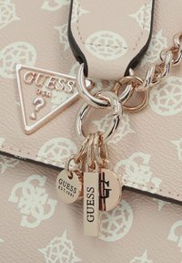 Borsa a mano in ecopelle rosa con motivo a logo in rilievo, dotata di hardware argentato, un'etichetta a triangolo e diversi dettagli a ciondolo.