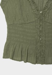 Olive green textured fabric with vertical ribs, ruffled edges, smocked midsection, and a row of small buttons down the center.