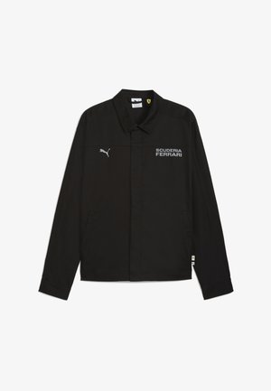 Černá bunda s límečkem, na které je bíle napsáno "SCUDERIA FERRARI". Měkká látka, dvě boční kapsy a vyšívané akcenty loga.