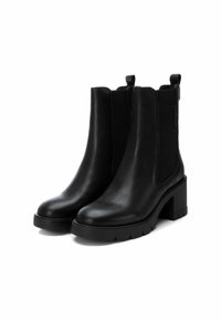 Botas de cuero negras hasta el tobillo con paneles laterales elásticos, tacones bloque gruesos y suelas texturizadas. Acabado liso y detalles mínimos.