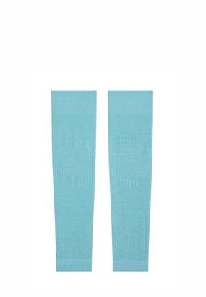 Personne athlétique portant un haut de sport bleu clair et des manchons, étirant les bras au-dessus de la tête, regardant sur le côté.