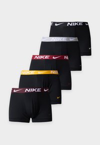 Πέντε ζευγάρια μαύρα ανδρικά εσώρουχα Nike με ελαστικές μέσες σε μαύρο, άσπρο, κόκκινο, κίτρινο και μαρόν, καθένα με το λογότυπο της Nike.