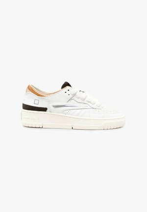 Witte lage sneaker met geperforeerde details, dikke zool en zwarte en beige accenten op de hiel en kraag, vanaf de zijkant gezien.