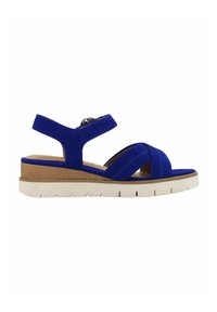Blue suede wedge sandals feature a cushioned footbed, cross straps, and an ankle strap with a circular metal accent. White rubber sole with grooves.