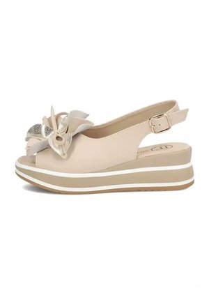 Beżowa sandały na koturnie z regulowanym paskiem zapinanym na klamrę, odkrytymi palcami oraz ozdobną warstwową kokardą wykonaną z materiałów metalicznych i tkanin na górze.