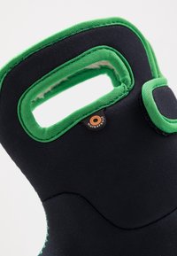 Czarna, wodoodporna rękawica neoprenowa z zielonymi akcentami. Posiada fakturowaną powierzchnię, wycięty uchwyt oraz wyraźnie widoczną etykietę wodoodporności.